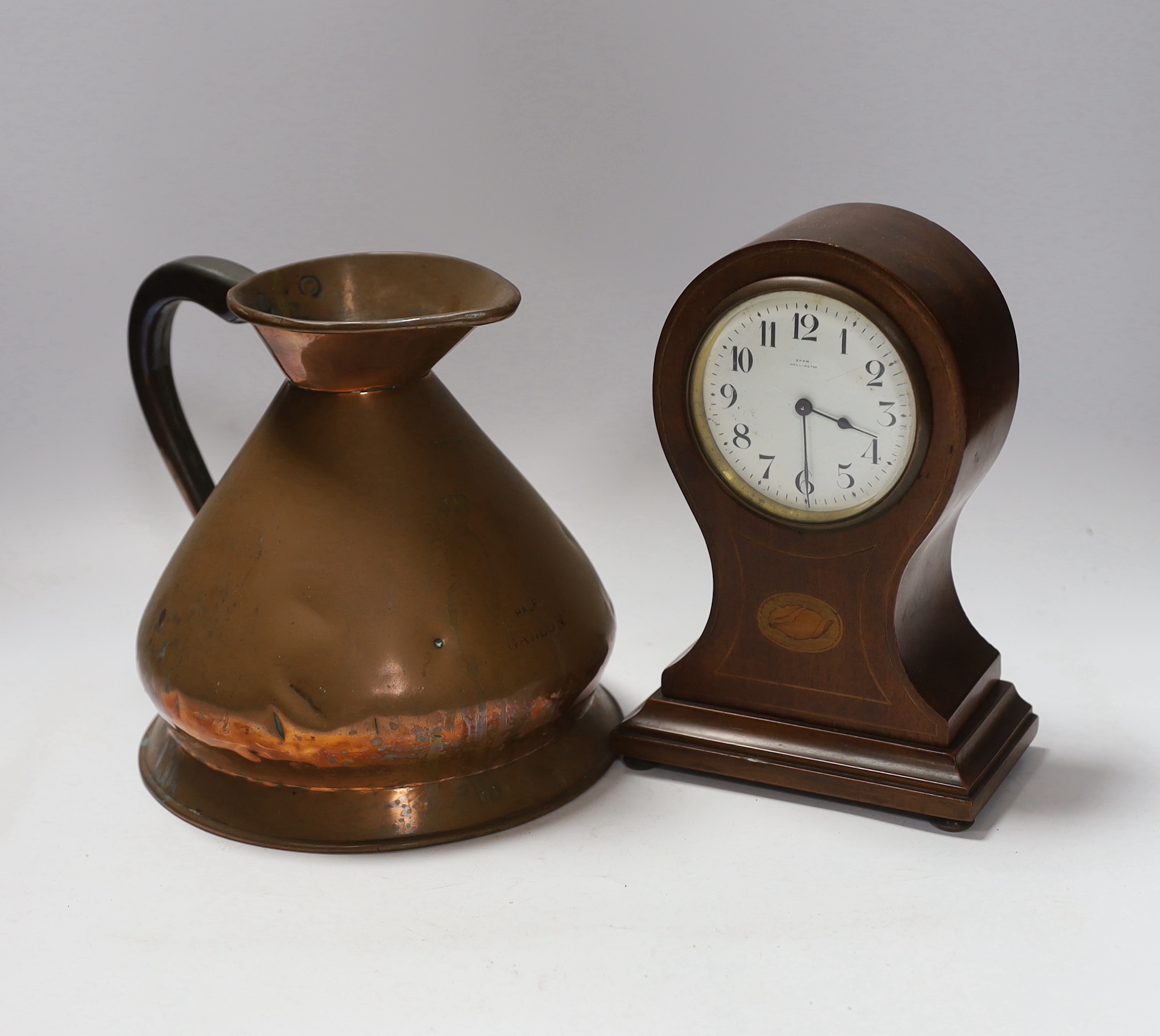 A copper measure jug and a mantel clock